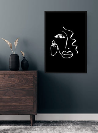 Minimalist line art poster of an abstract face, displayed in a modern room above a wooden dresser.