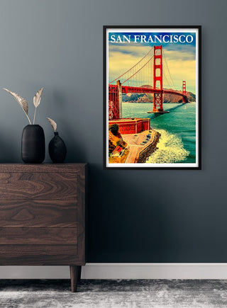 Framed San Francisco poster featuring the Golden Gate Bridge, displayed on a dark wall above a wooden dresser.