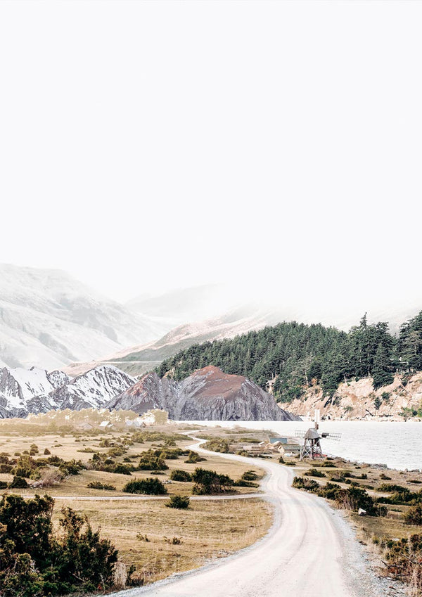 Scenic mountain road winding through snowy hills and pine trees, featured on Mountain road Plakat.