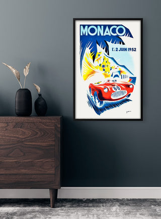 Framed Vintage Monaco Plakat featuring a classic red race car and bold 1952 event graphics on a grey wall.