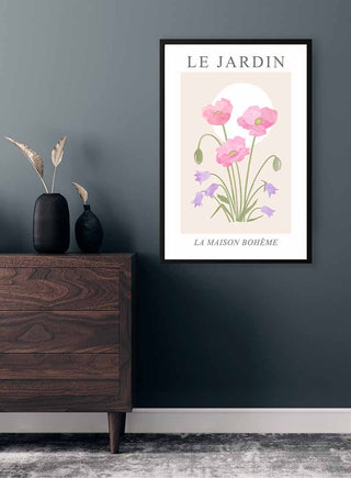 Le Jardin no. 3 Plakat featuring pastel poppy and bellflowers, framed and hung above a dark wooden dresser.