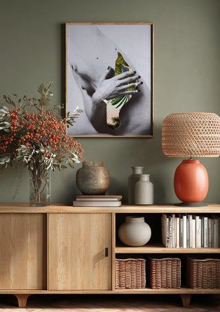 Duermen los volátiles by Rocio Montoya above a wooden sideboard on a sage green wall