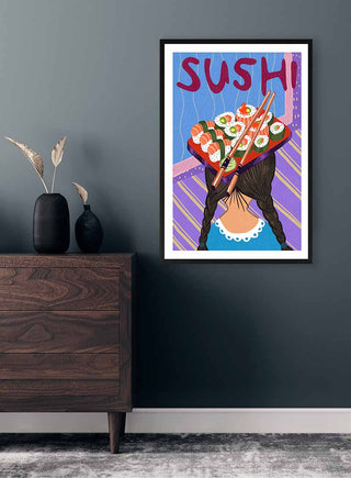 Colorful "På Hovedet Sushi" poster by Nina Broen showing a girl with sushi rolls on her head, hanging on a wall.