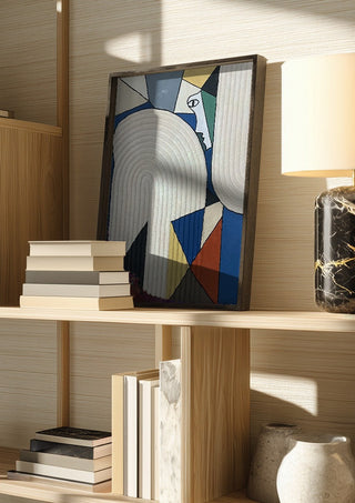Ossacip by Art Guveau in a dark frame on a wooden shelf beside books and a lamp