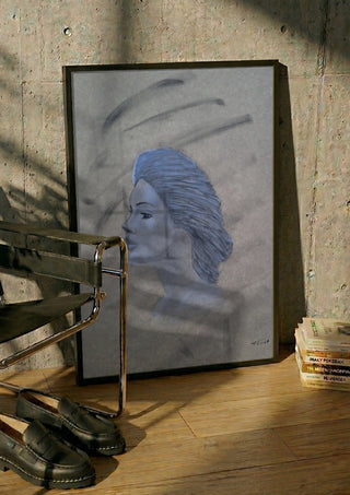 Blue Profile by Allheartsportraits in a black frame leaning against a concrete wall by a steel chair