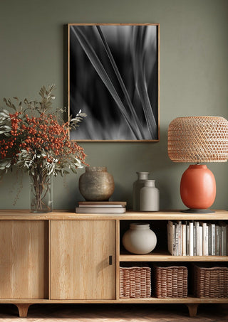 Diagonale Halme by Guido Lucker above a wooden sideboard on a sage green wall