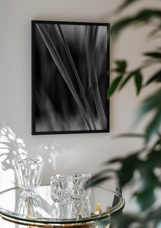 Diagonale Halme by Guido Lucker in a black frame above a glass table with crystal glassware
