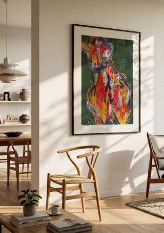 Red Figure by René J in a black frame in a bright dining room with wooden chairs