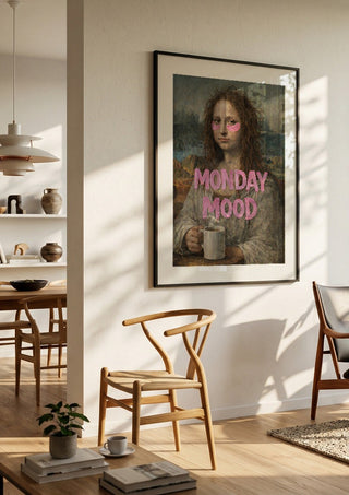 Monday Mood by Decker Studios in a black frame in a bright dining room with wooden chairs