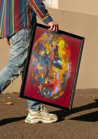 Colour Mask by René J carried in a black frame along a sunny street