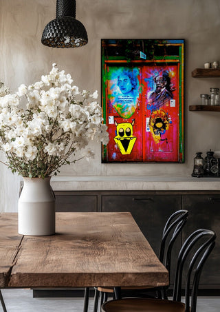 Graffiti Door by Pelecan Schneider in a black frame above a rustic table with white flowers
