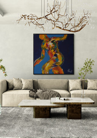 Dancer on Blue by René J in a black frame above a beige sofa under a branch chandelier