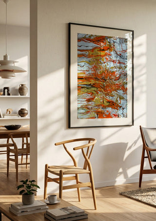 Orange Tide by Da Winters in a black frame in a bright dining room with wooden chairs