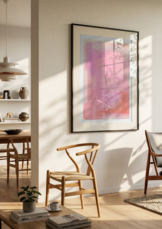 soft atmospheric colorfields by Iris Lehnhardt in a black frame in a bright dining room with wooden chairs