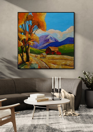Autumn Fields by Evgenia Smirnova in a black frame above a dark sofa with candlesticks on a round table