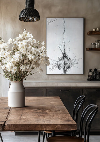Ship and Gulls by Justyna Kopania in a black frame above a rustic table with white flowers