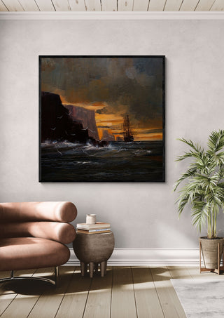 Ship by the Cliffs by Justyna Kopania in a black frame above a leather armchair beside a palm
