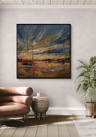 Masts in Golden Light by Justyna Kopania in a black frame above a leather armchair beside a palm