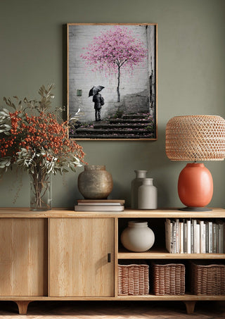 Spring x Banksy by Decker Studios above a wooden sideboard on a sage green wall