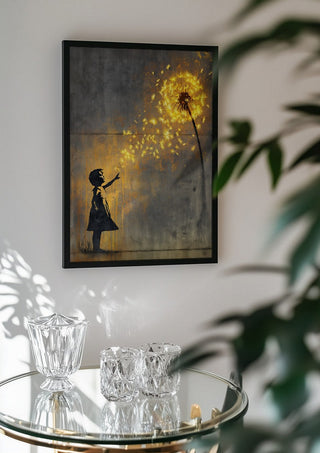 Golden Dandeloin x Banksy by Decker Studios in a black frame above a glass table with crystal glassware