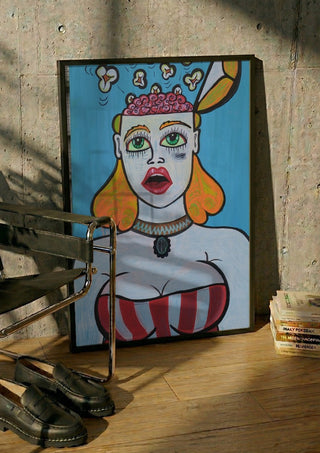 Popcornbrain by KaroGaiaArt in a black frame leaning against a concrete wall by a steel chair