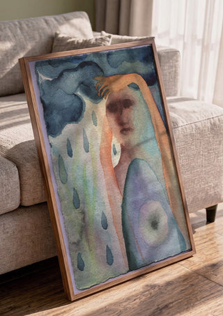 Under the Rain Cloud by Shimmering Ugly in a walnut frame leaning against a grey sofa