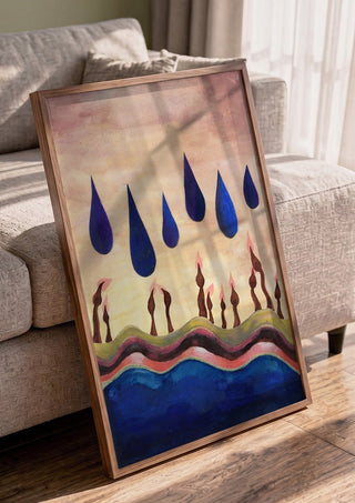 Candles Under Blue Drops by Shimmering Ugly in a walnut frame leaning against a grey sofa