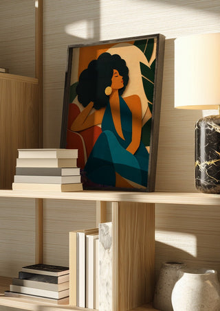 Modern Muse by ArtySjak in a dark frame on a wooden shelf beside books and a lamp
