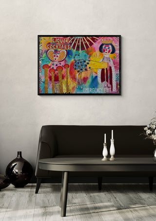 La noche confunde by María Burgaz in a black frame on a pale wall above a dark sofa with candlesticks