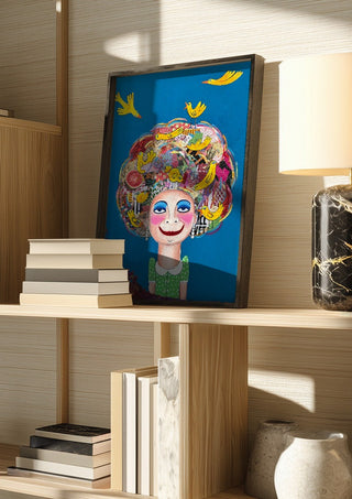 Pájaros en la cabeza by María Burgaz in a dark frame on a wooden shelf beside books and a lamp