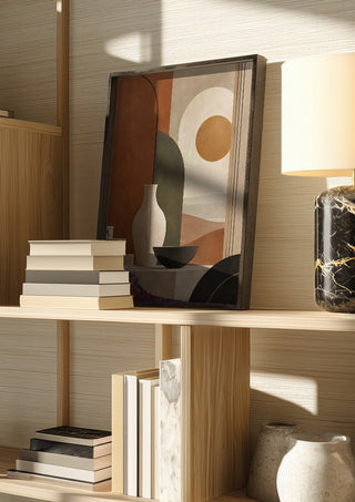 Earth Tones and Minimalist Shapes by TimlessArtworks in a dark frame on a wooden shelf beside books and a lamp