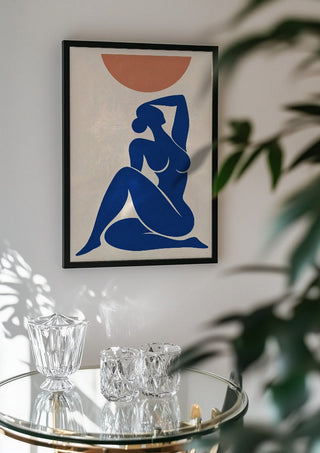 Abstract Nude Art Inspired by Henri Matisse by TimlessArtworks in a black frame above a glass table with crystal glassware