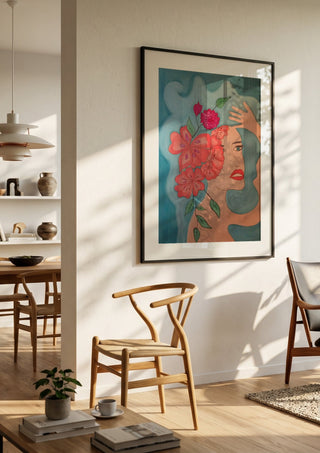 Flowers in head by Carmen Coduri in a black frame in a bright dining room with wooden chairs