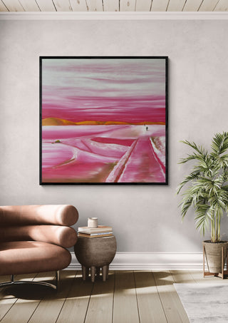 Pink Winter by Emil Walli in a black frame above a tan leather sofa beside a potted palm