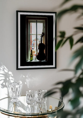 A Nice Day by Bent Hardervig in a black frame above a glass table with crystal glassware