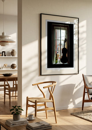 A Nice Day by Bent Hardervig in a black frame in a bright dining room with wooden chairs