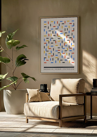 Bauhaus Dashes by Neil Stevens framed above a beige armchair beside a potted plant