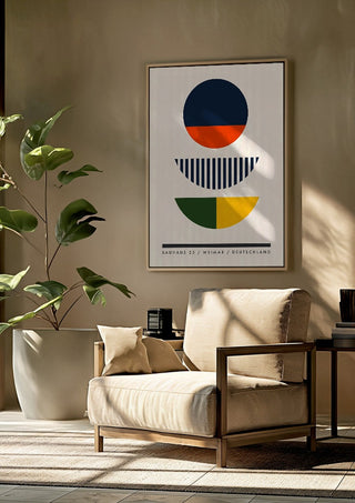 Bauhaus Circles by Neil Stevens framed above a beige armchair beside a potted plant