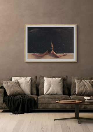 Holynight by Fran Rodriguez in a pale wooden frame above a grey sofa with cushions