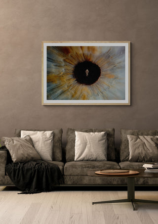 Inner Space by Fran Rodriguez in a pale wooden frame above a grey sofa with cushions