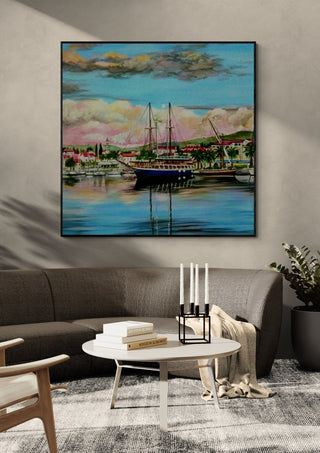 Nice City by Sunny in a black frame above a grey sofa with a round table and candlesticks