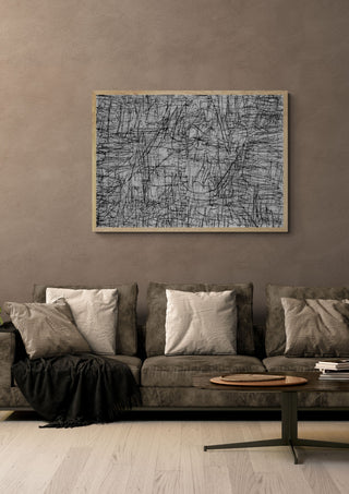 Any Point by Priit Ruttas in a pale wooden frame above a grey sofa with cushions