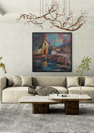House by the Water by PaKart in a black frame above a beige sofa under a branch chandelier