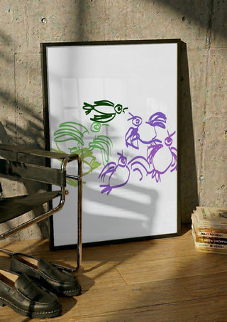 Birds in Green and Purple by Eva Hartman in a black frame leaning against a concrete wall by a steel chair