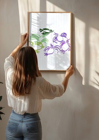 Birds in Green and Purple by Eva Hartman being hung on a sunlit wall