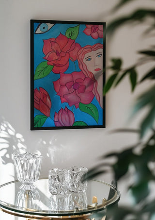 The watching Eye by Carmen Coduri in a black frame above a glass table with crystal glassware
