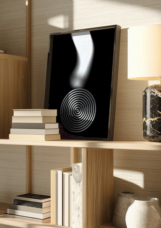 Echo by Aleksi Allan in a dark frame on a wooden shelf beside books and a lamp