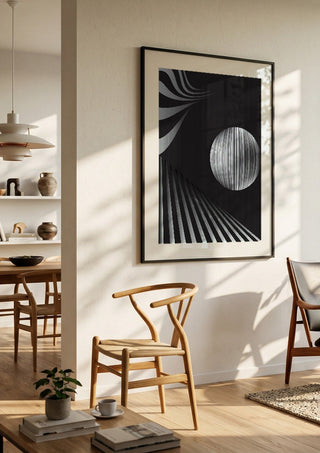 Monochrome II by Aleksi Allan in a black frame in a bright dining room with wooden chairs