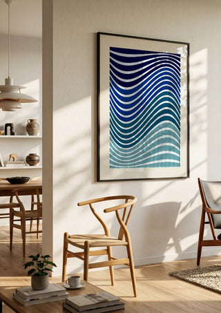 Aallot by Aleksi Allan in a black frame in a bright dining room with wooden chairs