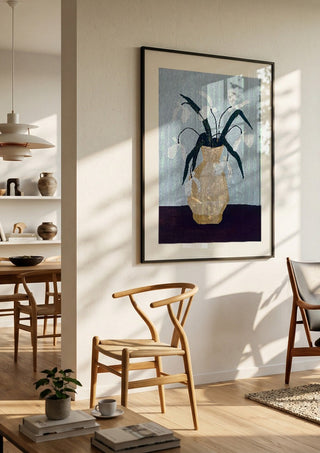 Vita blomster i beige vas by Rebecka Hansson in a black frame in a bright dining room with wooden chairs